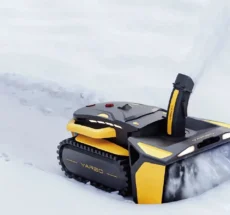 Robot Yarbo configurato come spazzaneve su un vialetto innevato