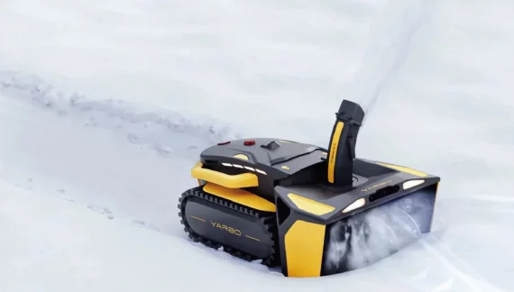 Robot Yarbo configurato come spazzaneve su un vialetto innevato